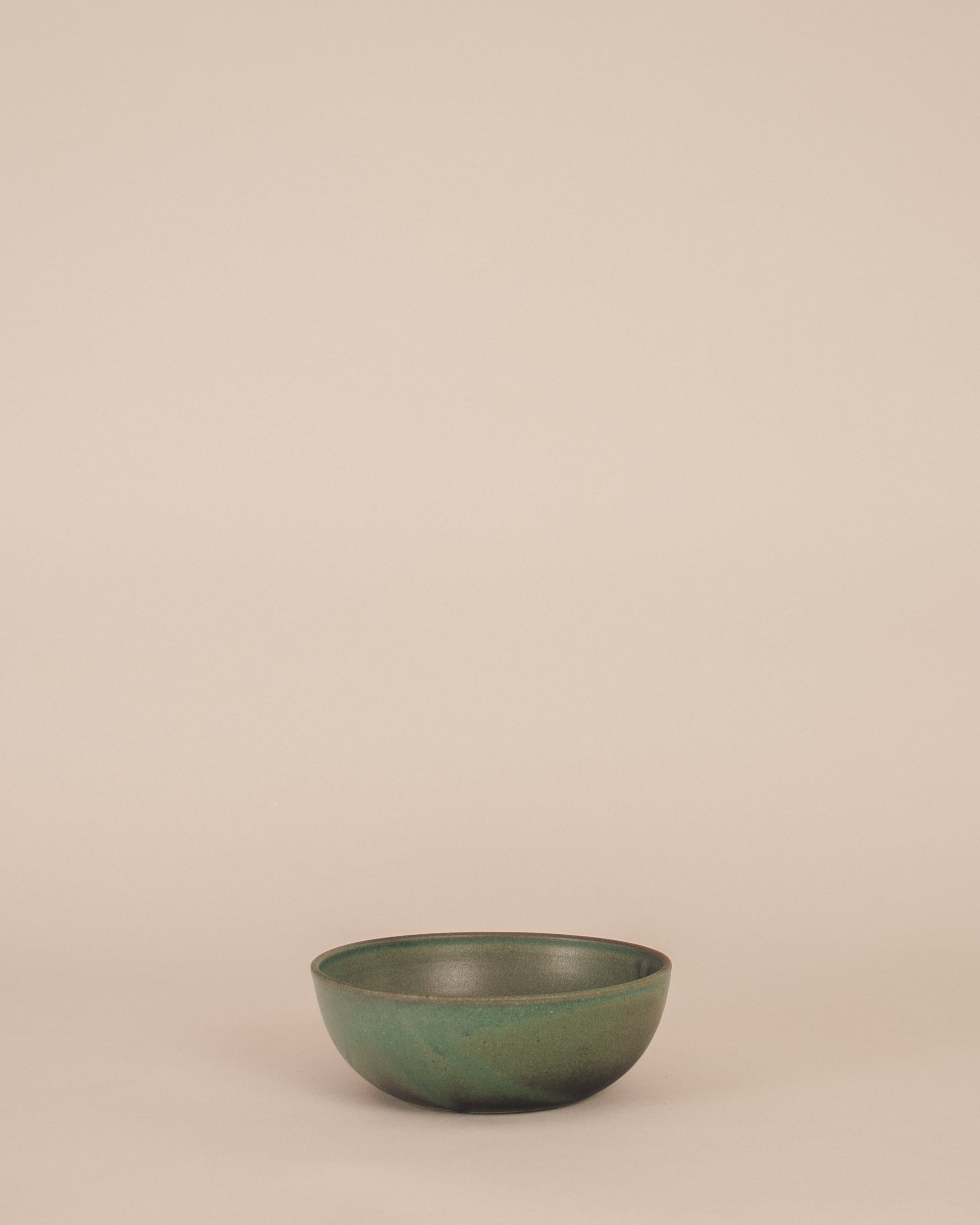 Green ceramic bowl on a beige background
